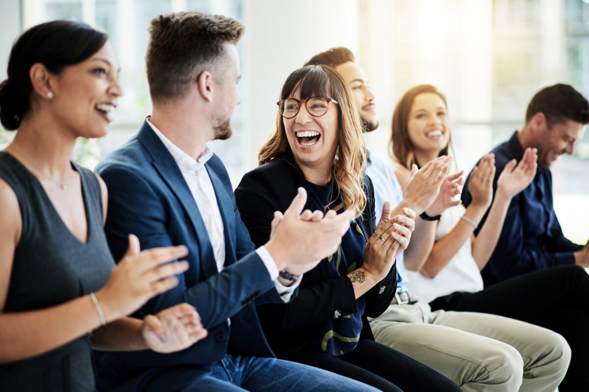 Applauding audience with laughing woman in the middle