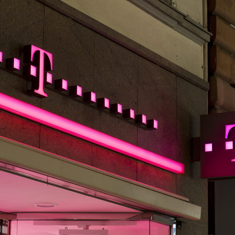 Telekom Logo leuchtet an Hauswand