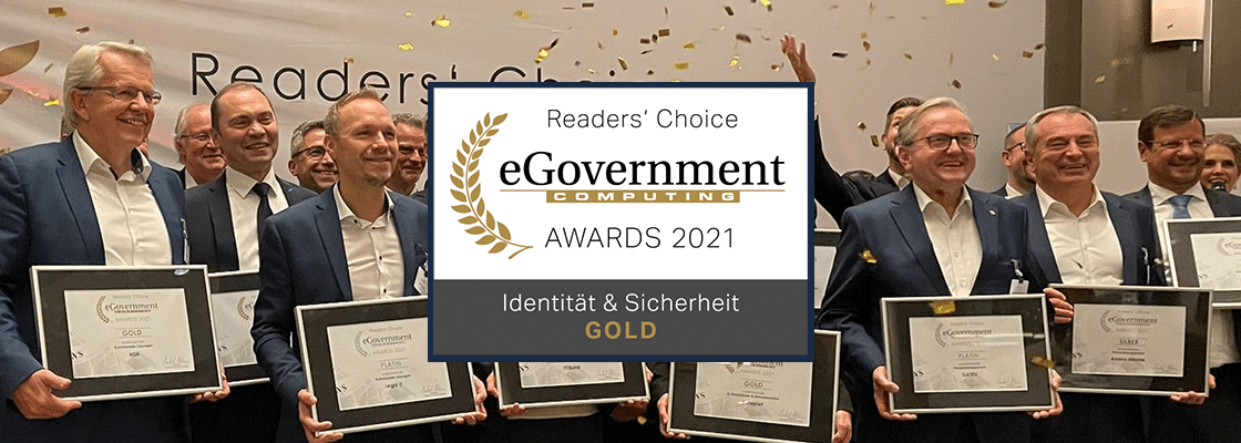 Plakette für die Auszeichnung Gold beim eGovernment Computing Readers' Choice Award 2021, im Hintergrund präsentieren die Ausgezeichneten ihre Urkunden