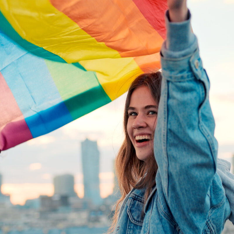 Frau lässt Regenbogenflagge wehen