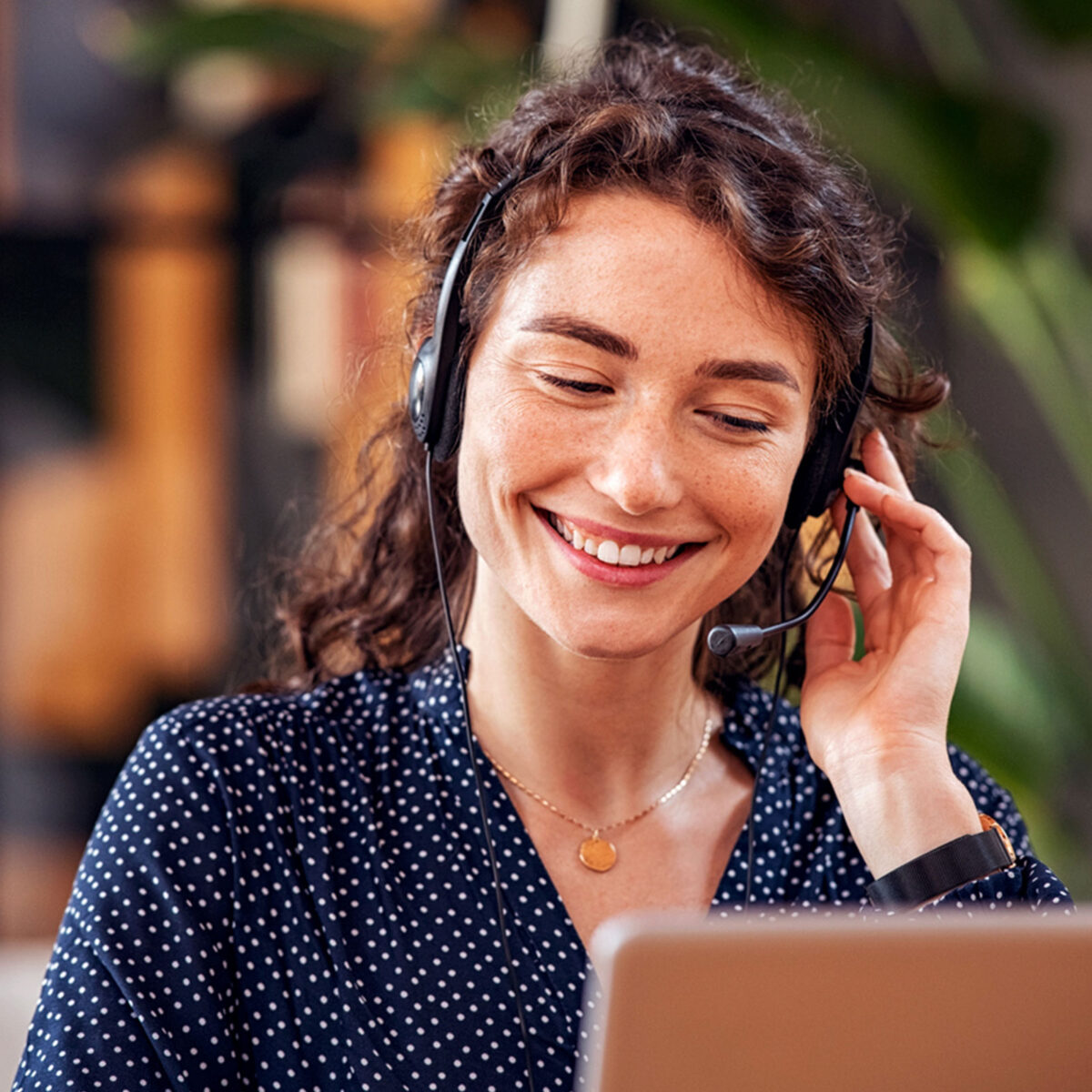 Frau mit Headset am Laprop