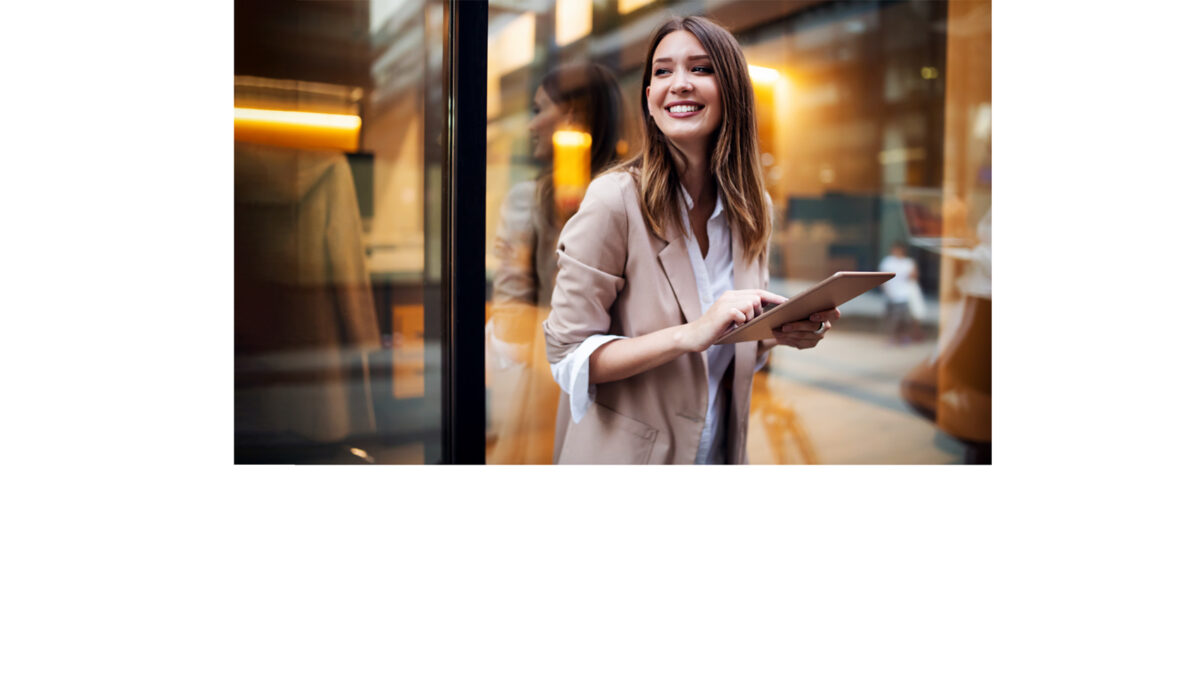 Frau steht mit Tablet in der Hand vor einer Boutique