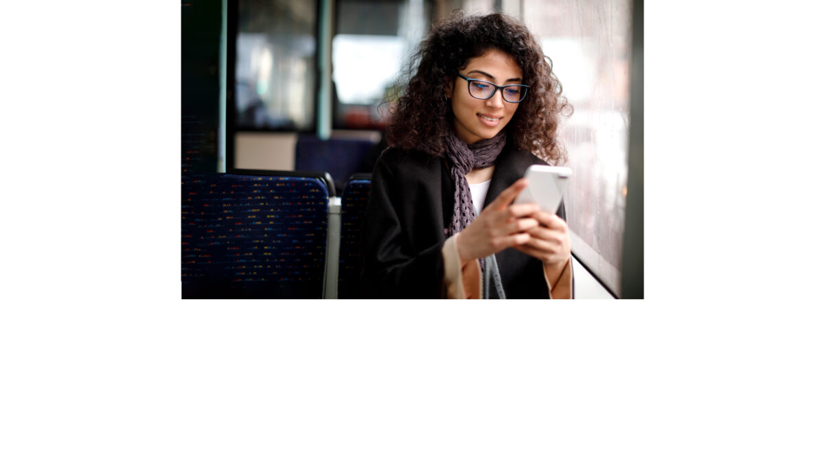 Junge Frau im öffentlichen Verkehrsmittel schaut auf ihr Handy