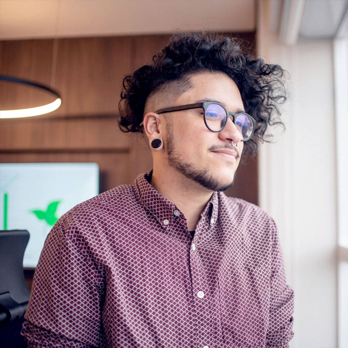 Mann mit Brille und Septum am Fenster