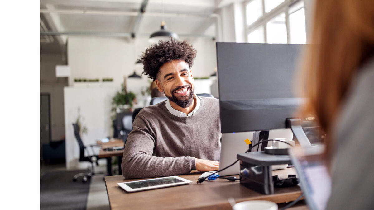 Mann mit braunem Pulli am Arbeitsplatz