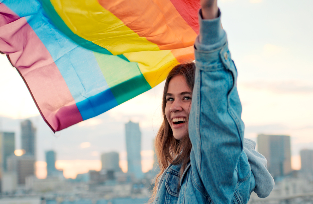 Frau lässt Regenbogenflagge wehen