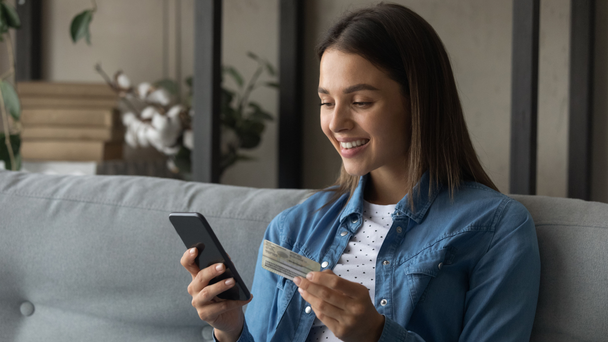 Frau mit Ausweis und Handy in Jeanshemd