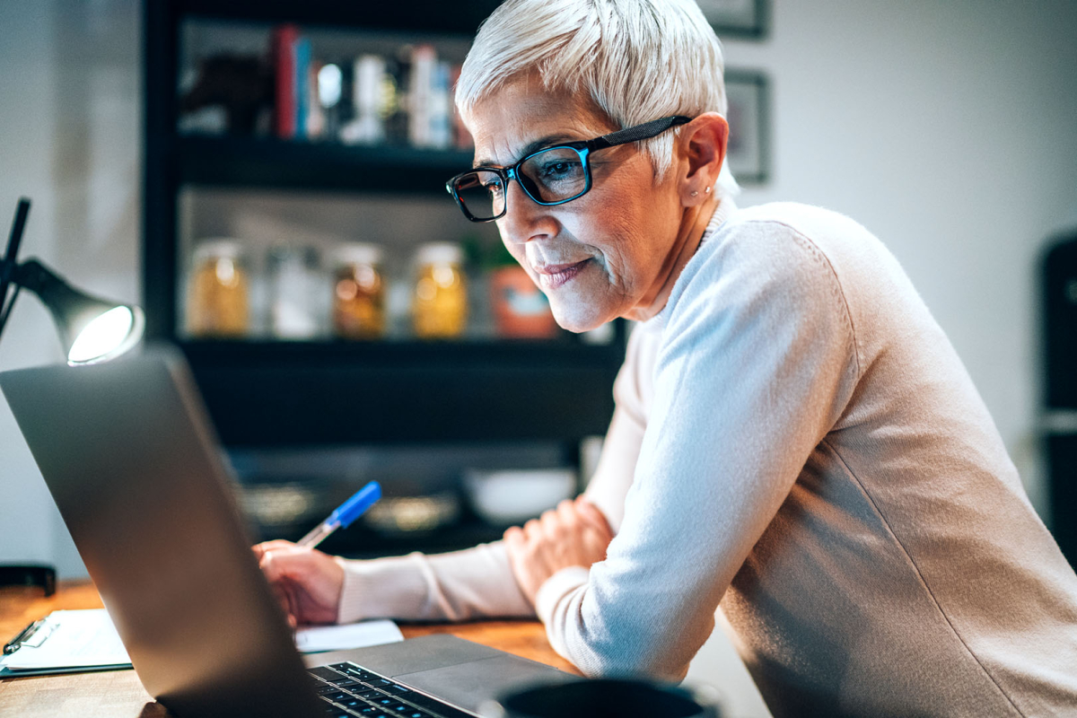 Frau mit Brille sitzt am Laptop