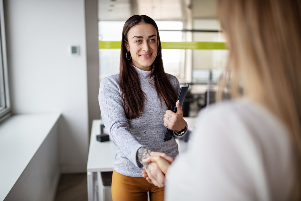 Woman greets colleague with handshake