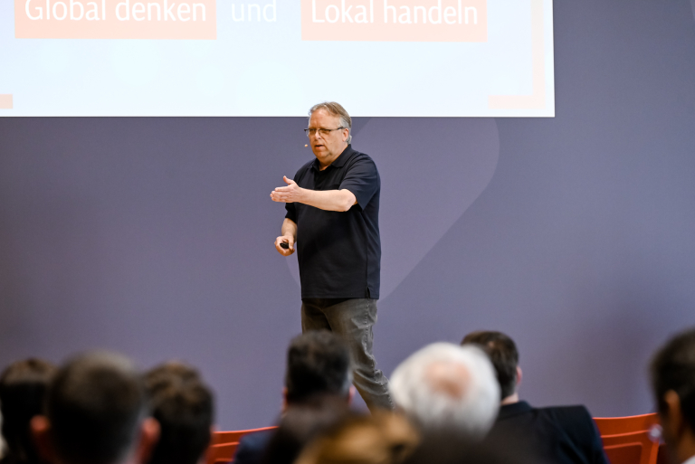 Jörg Heynkes gestikuliert während eines Vortrags auf der Jahrestagung