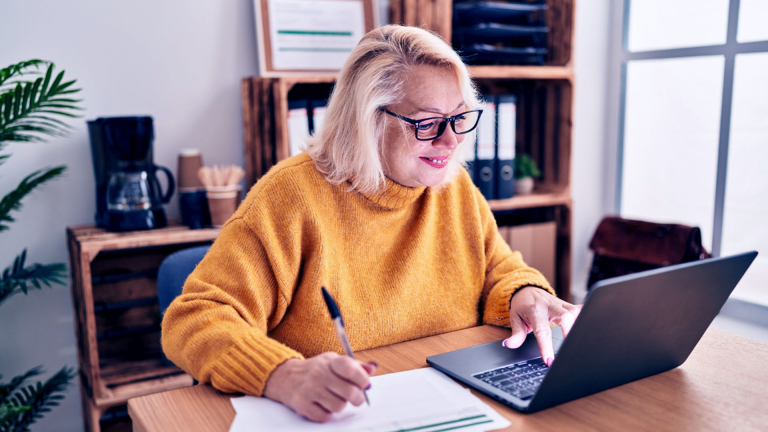 Ältere Frau mit grauem Haar im Homeoffice