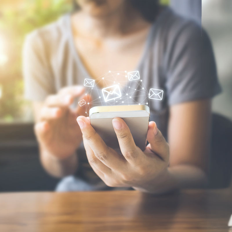 Frau sitzt mit Smartphone am Tisch