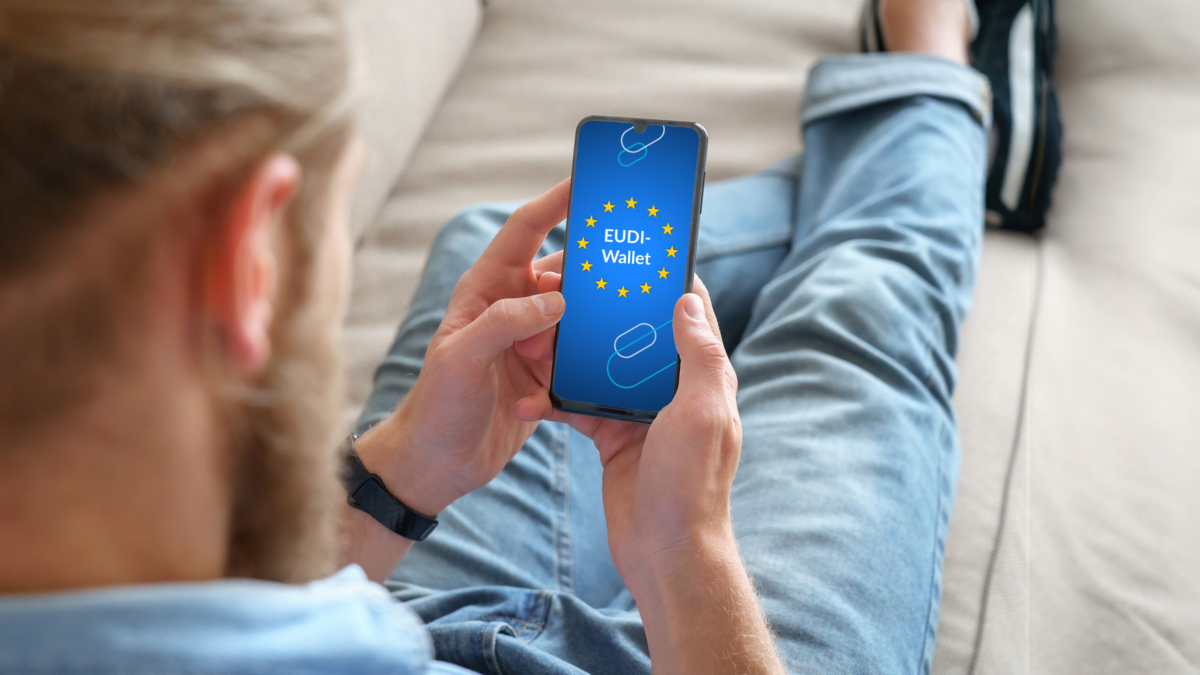 Mann sitzt mit Smartphone auf dem Sofa