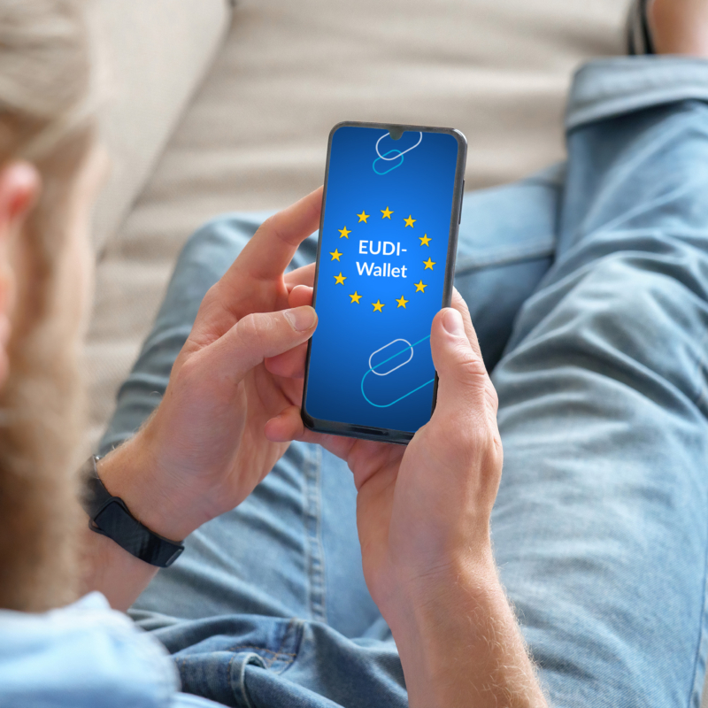 Mann sitzt mit Smartphone auf dem Sofa