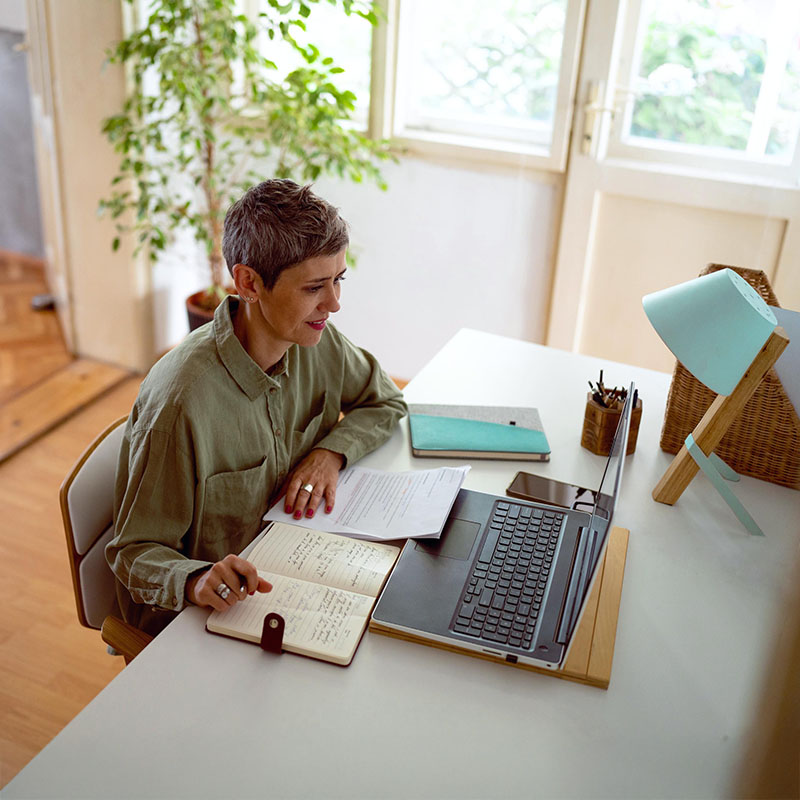 frau-in-bluse-sitzt-am-laptop