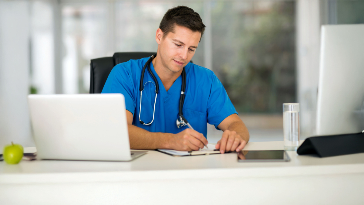 Doktor im blauen Kittel am Schreibtisch