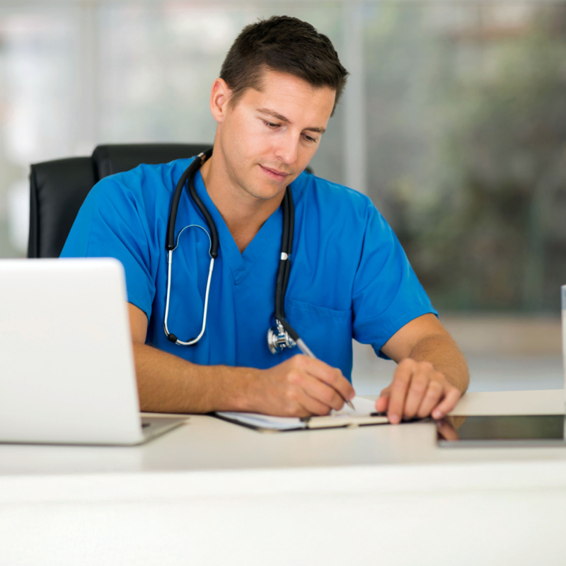 Doktor im blauen Kittel am Schreibtisch